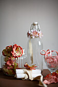 Fabric ribbons with artificial flowers around glass jars
