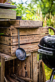 Wooden crates, pan, and kettle grill in the garden