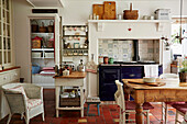 Blauer Holzofen in Wohnküche mit Terrakotta-Fliesenboden