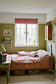 Patchwork quilt on wooden bed under the window