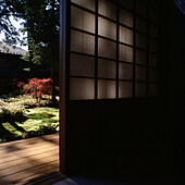 Japanisches Haus mit Blick auf Holzterrasse und Garten