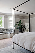 Master bedroom with double bed and built-in bench by the window