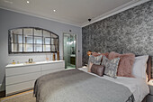 Spacious bedroom with monochrome wallpaper and bathroom ensuite