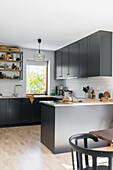 Open kitchen with dark cabinet fronts and white subway tiles