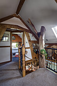 Staircase landing with tree trunk in attic bedroom