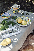 Gedeckter Tisch mit Zitronen dekoriert, im Garten