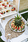 Fruits in paper cones and pineapple and melon plate