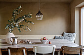 Long wooden dining table, vase with eucalyptus branches