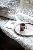 Cosy seating area, tray with mug and booklet