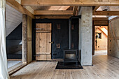 Wood-burning stove in the attic room with wooden beams