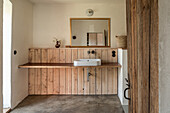 Puristisches Bad mit Holzbrett als Waschtisch und Estrichboden