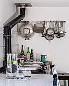 Cooking utensils hang from a rack above the Aga
