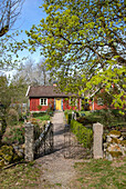 Rotbraunes Holzhaus mit Bauerngarten