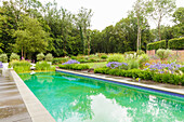 Flowerbeds with decorative lilies by the pool in the luxurious garden
