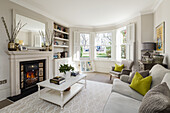 Classic living room in white with open fireplace and bay window