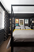 Doppelbett mit Gestell im Schlafzimmer mit schwarzer Wand