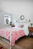 Double bed with red and white bedspread, lantern on windowsill