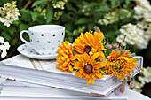 Bouquet of rudbeckia arranged on stack of books