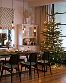 Dining table decorated with moss and illuminated Christmas tree