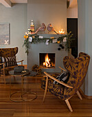 Vintage armchair in front of fireplace with fire, above Christmas decoration