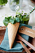 Waffle cone with pea blossom on place setting