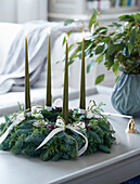 Advent wreath made of coniferous branches with green candles