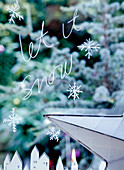 Fensterdekoration mit Schneeflocken und 'Let it snow' Schriftzug
