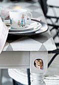 Place setting on table with chequered surface, underneath small mouse