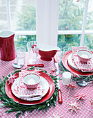 Weihnachtlich dekorierter Tisch mit rot-weißem Geschirr