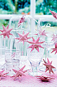 Glasses with red and white star-shaped lights on table