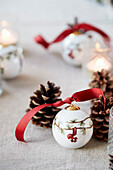 Christmas ball with red decorative ribbon and pine cone
