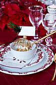 Red and white Christmas table setting with gold decorated glass ball