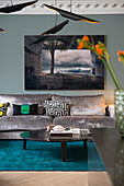 Velvet sofa, above it large-format photograph hung on the wall in the living room