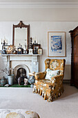 Nonworking fireplace with eclectic collection and wing chair with floral pattern upholstery
