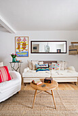 White seating furniture with colorful throw pillows and coffee table in white painted living room