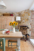 Dining area with Mediterranean flair, in the background disused fireplace as wood store and sandstone wall