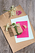 Päckchen und Briefumschlag mit Holunderblüten und Dekogras