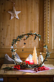 Christmas decorative wreath with candles and fir tree on a wooden table