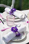 Place setting with delphinium flowers as a napkin ring