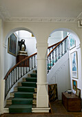 Hall with curved staircase, French mantel clock in the background