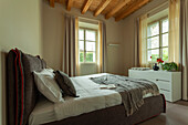 Doppelbett mit gepolstertem Betthaupt und weiße Kommode im Schlafzimmer