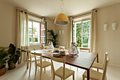 A simple dining room with light-coloured chairs