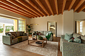 Upholstered sofas in lounge with wooden ceiling and terrace access