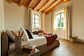 Bed with pillows in bedroom with wooden ceiling