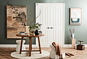 Round oak table, light concrete stool in front of white double door