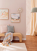 Bench with cushions and blanket in the room in pastel shades