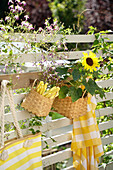 Garderobenleiste mit Besteckkorb und Sonnenblumen als Zaundeko