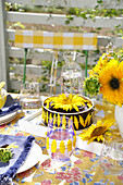 Gedeckter Tisch mit Sonnenblumenkuchen im Freien