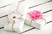 Geschenkverpackung mit DIY-Papierblüten dekoriert