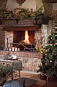 Weihnachtlich dekorierter Kamin mit Feuer